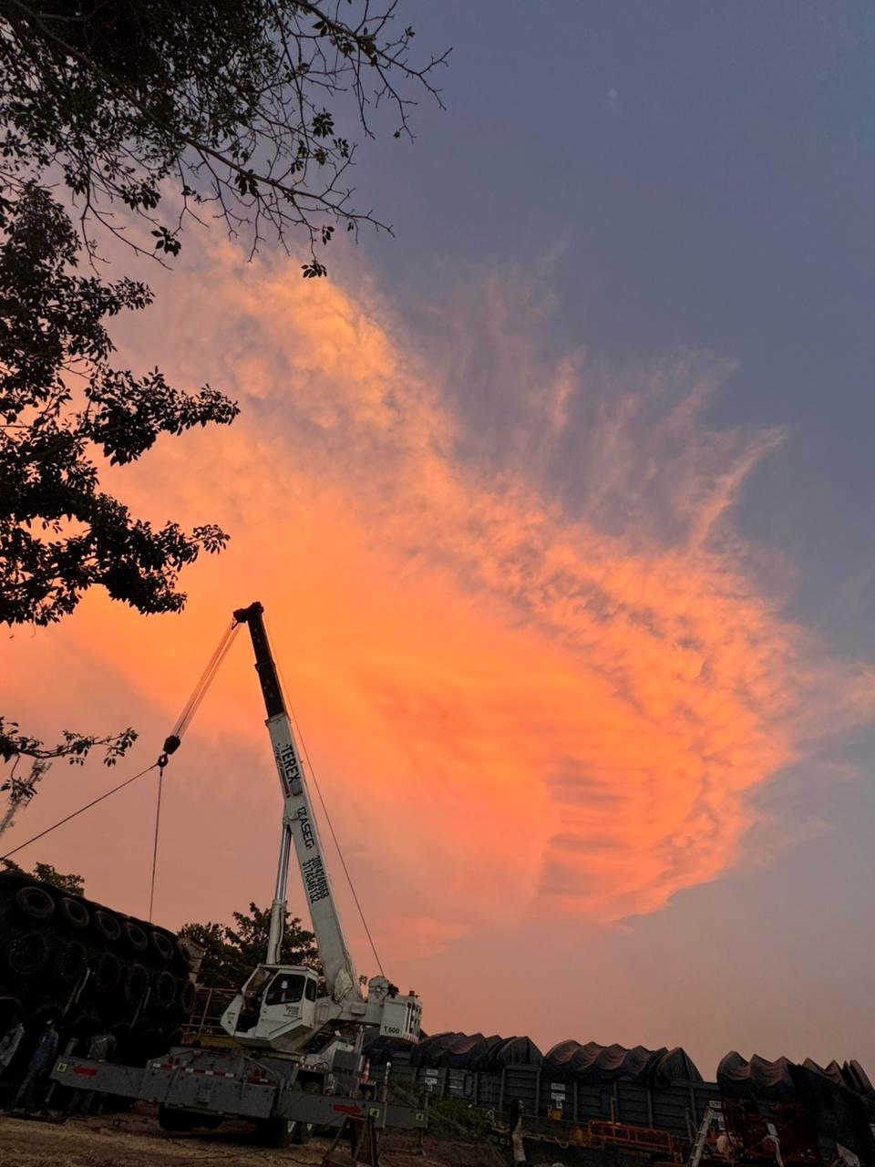 Grúa en maniobra con cielo naranja